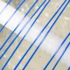 Close-up of blue plastic strings stretched diagonally over a white corrugated cylindrical object with a blurred background.