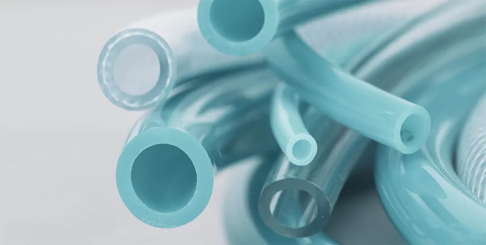 Close-up view of several transparent and opaque blue plastic tubes of different diameters, arranged in parallel on a light background.