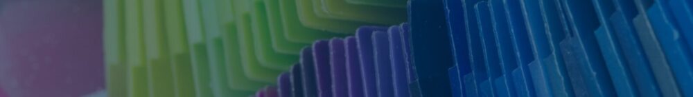 Close-up of stacked, colorful plastic dividers or folders arranged in overlapping rows, featuring shades of green, yellow, purple, and blue.