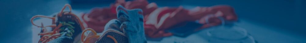 A pair of athletic shoes, a towel, and a water bottle are placed on the floor.