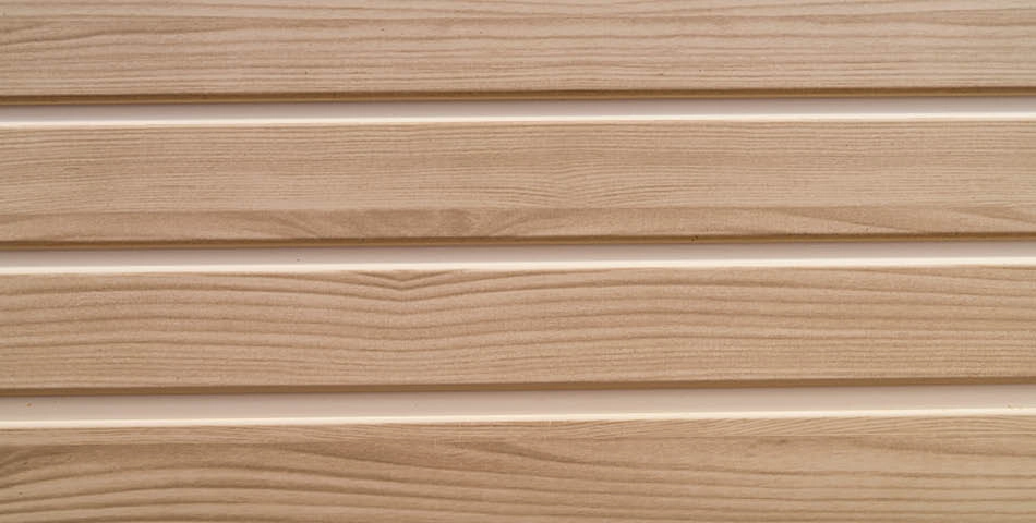 Close-up of light wood paneling with horizontal grooves and visible grain patterns.