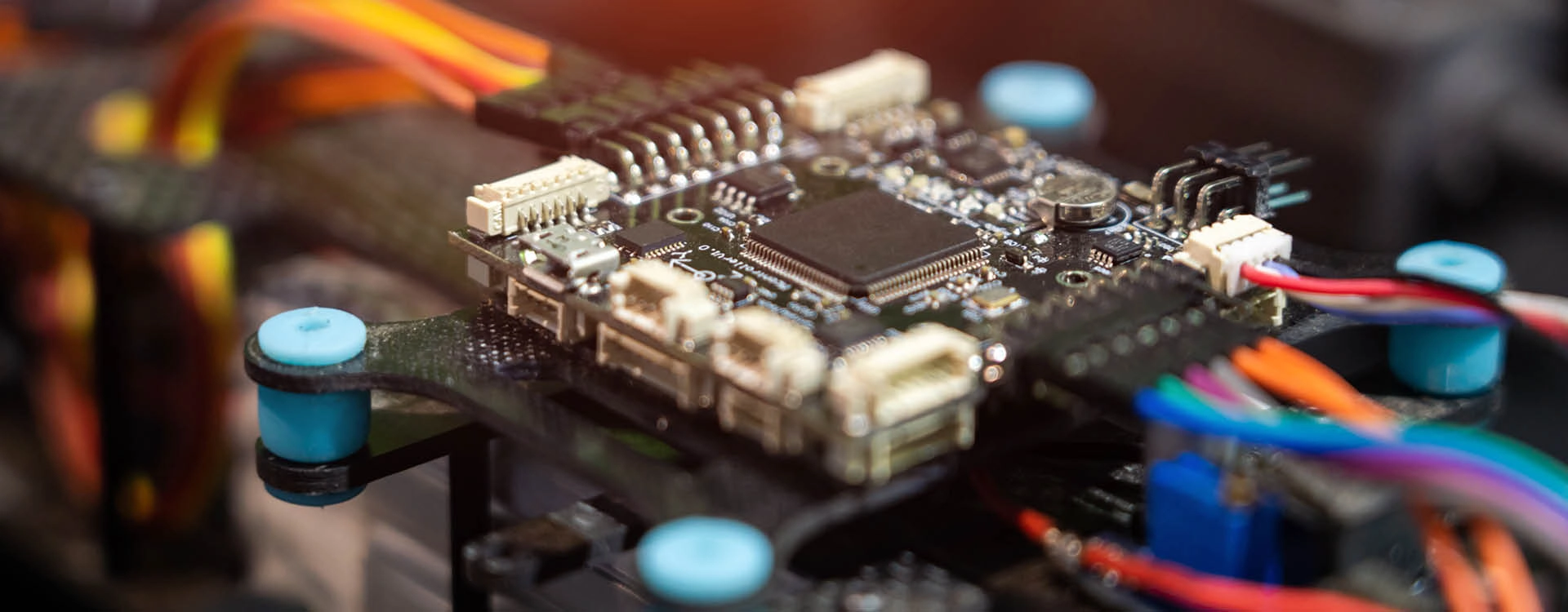 Close-up of an electronic circuit board with various connectors, components, and colorful wires attached.