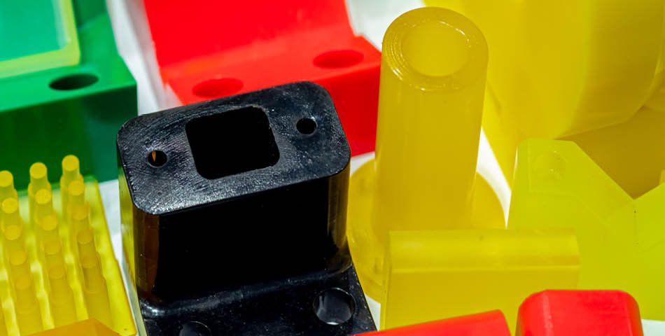 Assorted colorful plastic industrial parts, including red, yellow, green, and black components, arranged closely together.