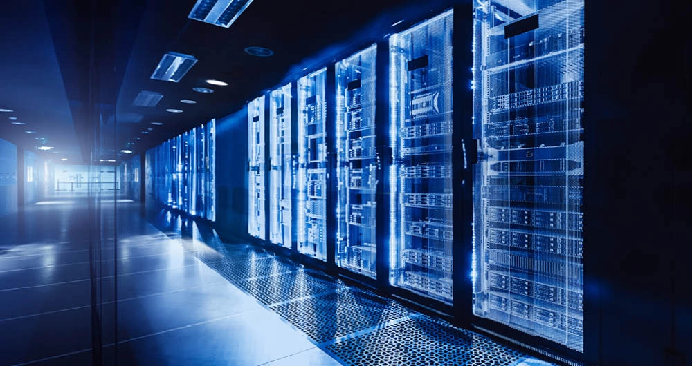 A modern data center hallway with rows of illuminated server racks and reflective flooring.