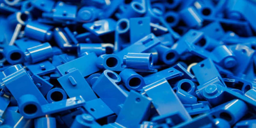 A pile of assorted blue plastic LEGO Technic pieces, including beams and connectors, closely stacked together.