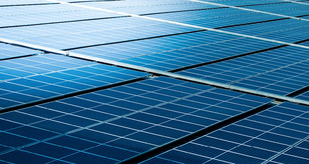 Close-up view of blue solar panels arranged in rows, reflecting sunlight.