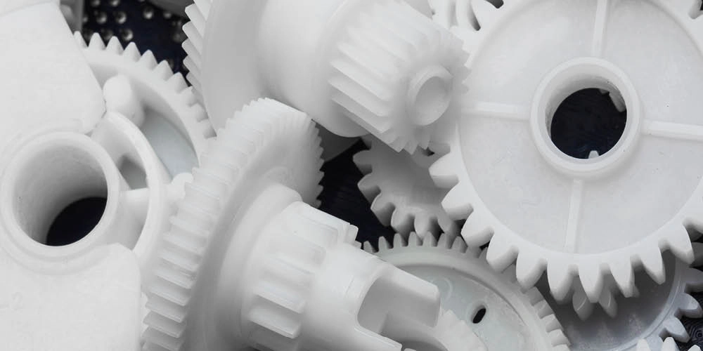 A close-up of several white plastic gears of various sizes overlapping each other.