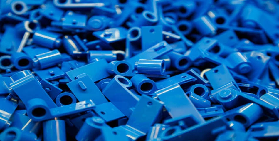 A pile of assorted blue plastic LEGO bricks and pieces viewed up close.