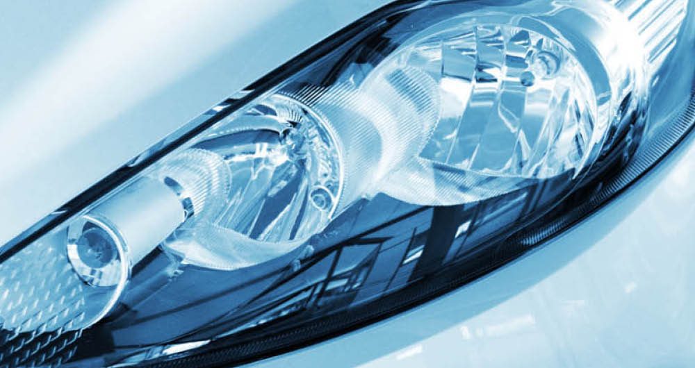 Close-up view of a modern car headlight, showing the reflective surfaces and detailed internal components.
