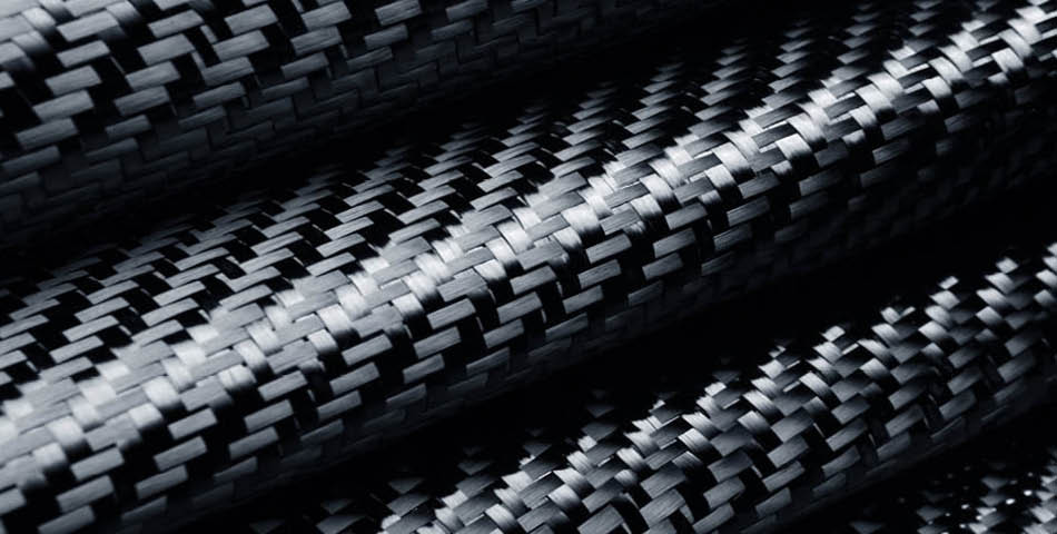 Close-up of tightly woven black carbon fiber fabric, showing its distinctive checkerboard pattern and smooth, glossy finish.