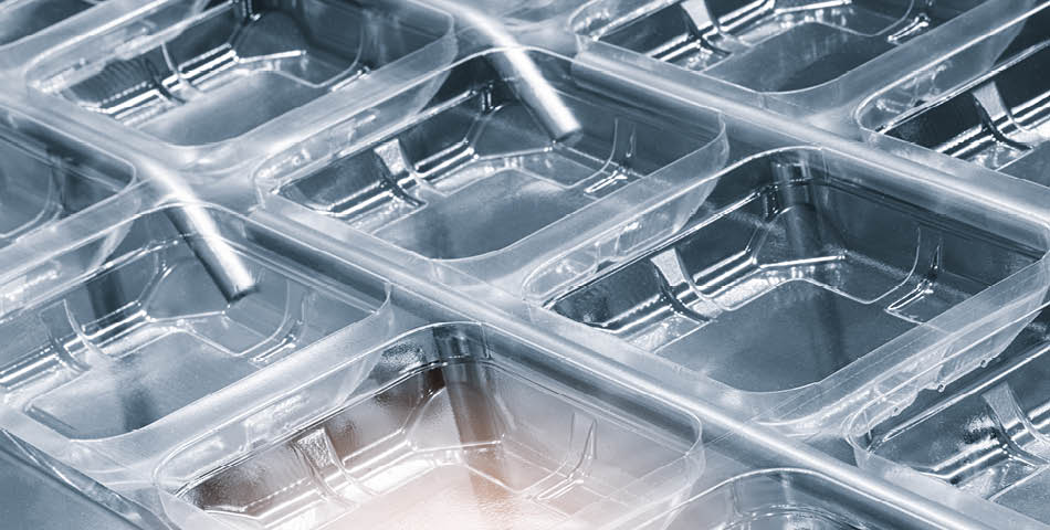 Close-up view of a plastic blister packaging tray featuring multiple rectangular compartments in a grid pattern, made from polysulfones high-heat & chemical resistant compounds for enhanced durability.
