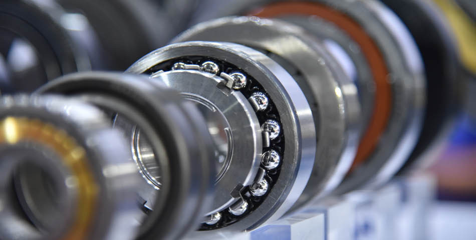 Close-up view of several ball bearings arranged in a row, showing metal components and exposed ball bearings.